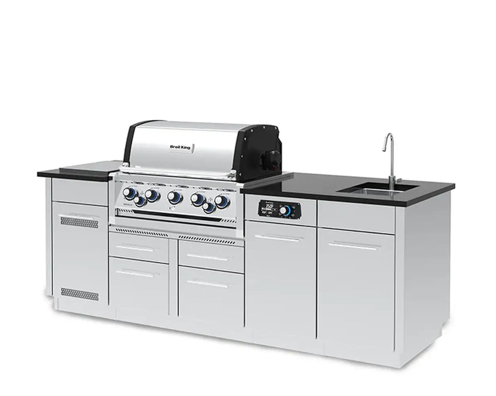 A slightly different left-front perspective photograph of the Broil King Imperial QS 590iE Smart Grill Island, focusing on the stainless steel construction, black countertops, central control panel with blue LED dials, and side cabinet layout on a plain white background.