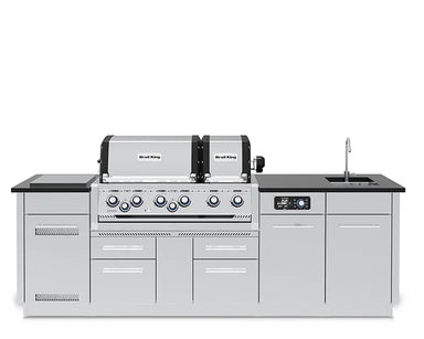 Front profile of the fully assembled Broil King Imperial QS 690iE Smart Grill Island featuring a dual-hood grill, digital control panel, side burner, and sink.