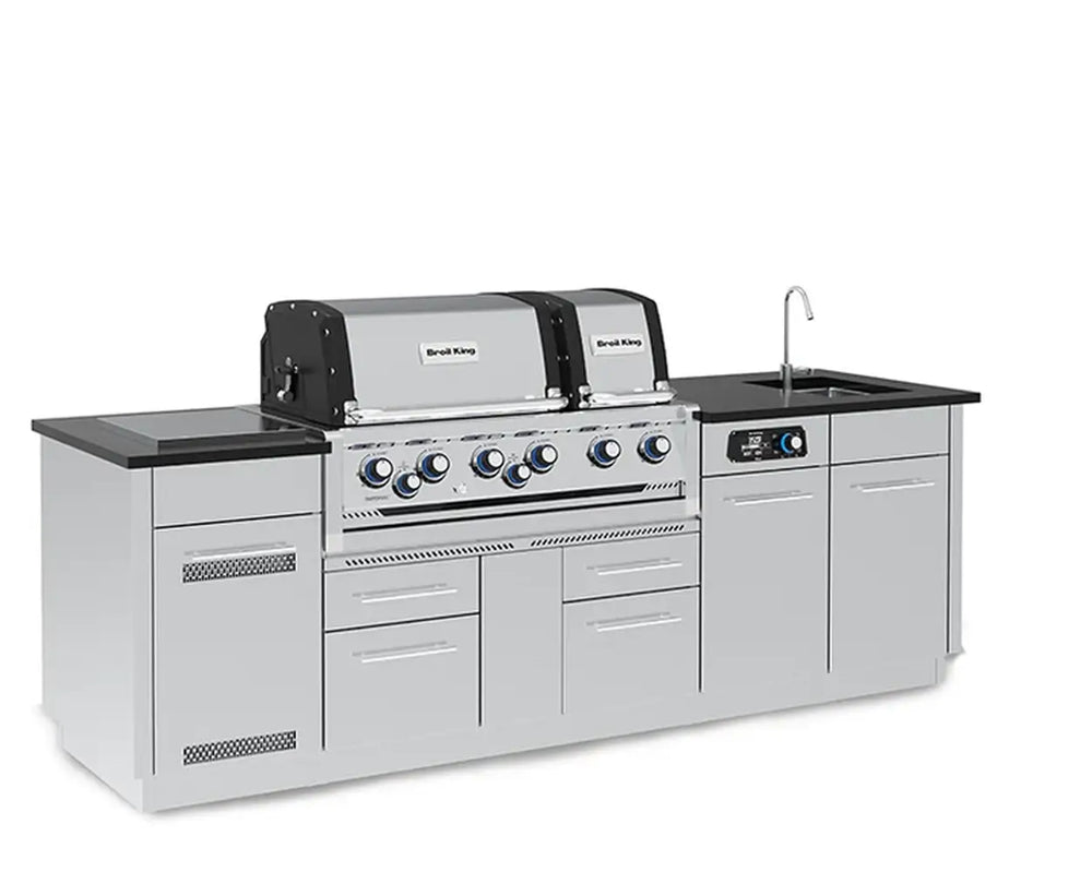 Three-quarter perspective view from the left of the Broil King Imperial QS 690iE outdoor kitchen island highlighting the side burner and stainless steel cabinetry.