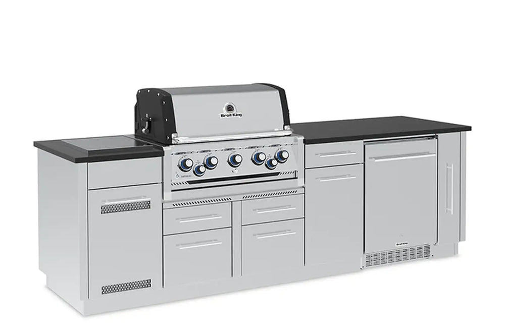 Angled right view of the Broil King Imperial S 590iF built-in gas grill island, highlighting the integrated outdoor fridge, sleek stainless steel finish, and ample prep space.