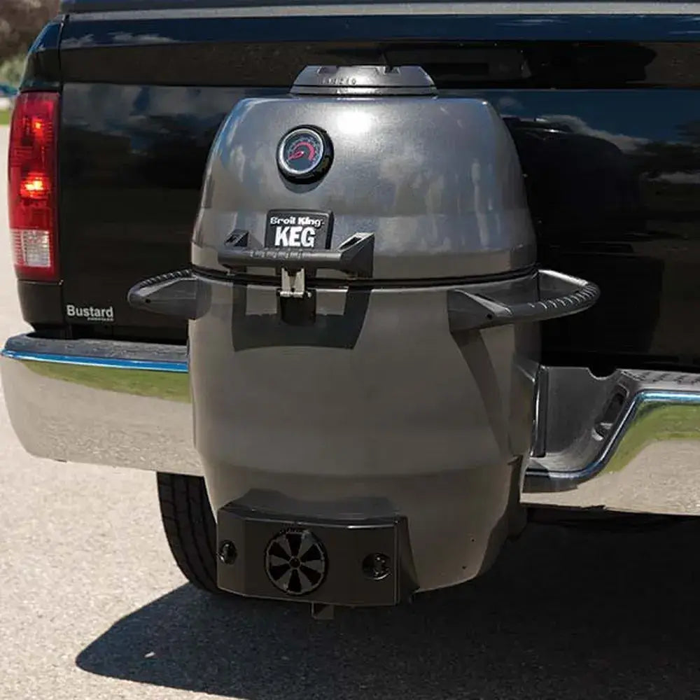 Broil King Keg 5000 kamado charcoal grill mounted to a pickup truck hitch, shown as a portable tailgating charcoal grill.