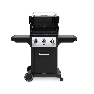 Broil King Monarch 320 freestanding gas grill with lid open, showing primary cooking grates, warming rack, three-burner cook box, and black cart with wheels