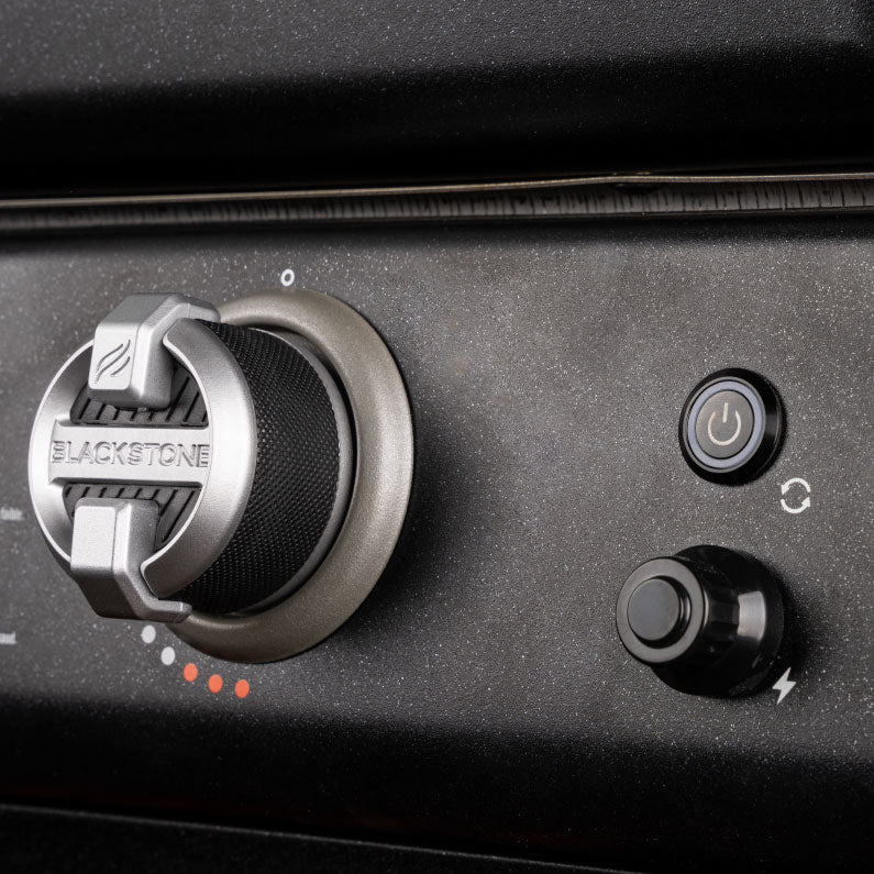 Close-up of Blackstone pizza oven ignition dial with textured control knob and power button