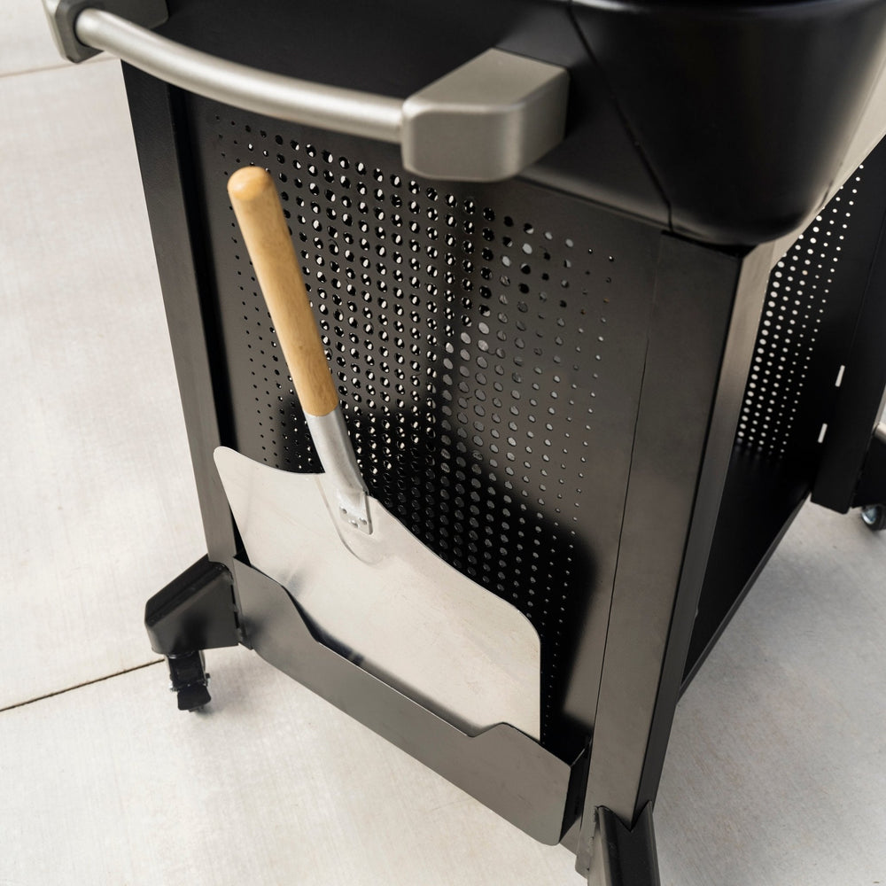 Mounted pizza peel holder with wood handle attached to the side of Blackstone pizza oven stand