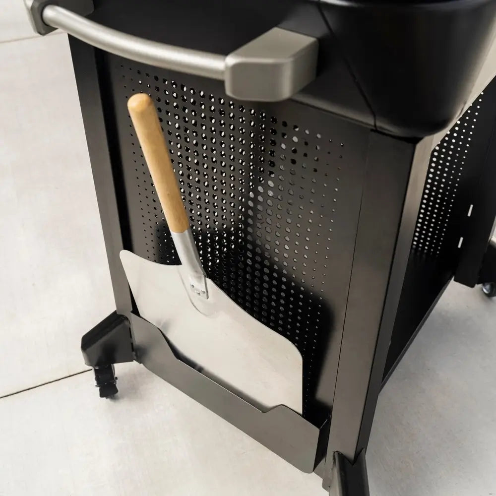 Mounted pizza peel holder with wood handle attached to the side of Blackstone pizza oven stand