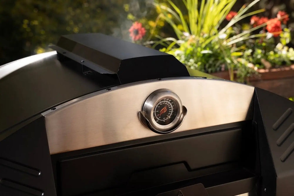 Close-up of built-in temperature gauge on Blackstone pizza oven stainless steel hood