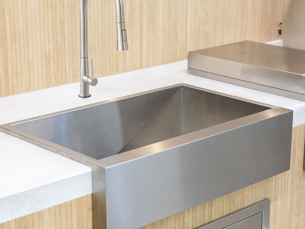 Summerset 32-inch stainless steel farmhouse sink with modern faucet in an outdoor kitchen.
