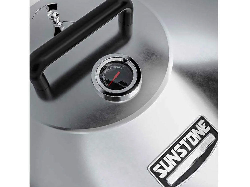 Close-up of Sunstone grill hood thermometer and handle on brushed 304 stainless steel lid with Sunstone logo.