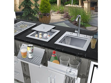 Sunstone insulated ice chest installed in outdoor kitchen counter beside sink, used for chilling drinks and ice with stainless lid.