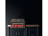 Closed True Flame grill installed in a modern outdoor kitchen, red LED-lit knobs visible against dark cabinetry.