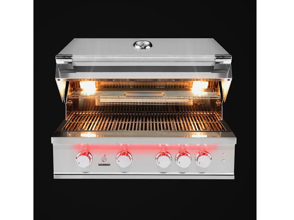 Overhead front view of True Flame grill with lid open, cooking grates illuminated by bright internal halogen lights.