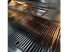 Full interior view of the grill showing wide cooking grates and removable stainless steel tray on the upper rack.