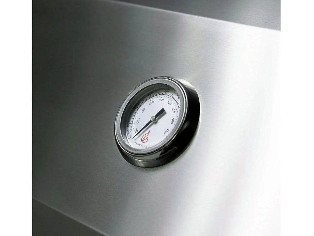 Close-up of built-in analog temperature gauge on the stainless steel lid of a True Flame gas grill.