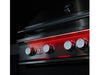 Night view of True Flame grill with red LED-lit control knobs and sleek stainless steel exterior.