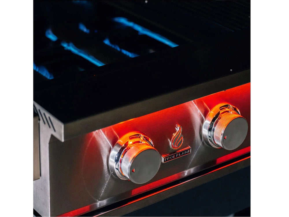 Close-up of True Flame grill's dual LED-lit control knobs with visible blue burner flames in background.