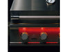 Partial close-up of True Flame grill’s stainless steel hood, built-in thermometer, and glowing red control knob.