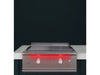 True Flame built-in gas griddle installed in an outdoor kitchen with stainless steel construction and red LED-lit control knobs.