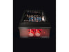 Night view of True Flame wok burner in use with visible blue flames under stainless steel grates and glowing red knobs.