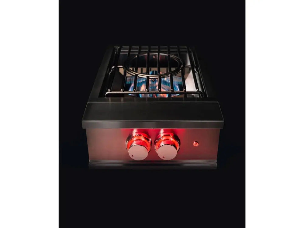 Perspective shot of True Flame wok burner ignited with strong blue flames beneath the circular wok grate.