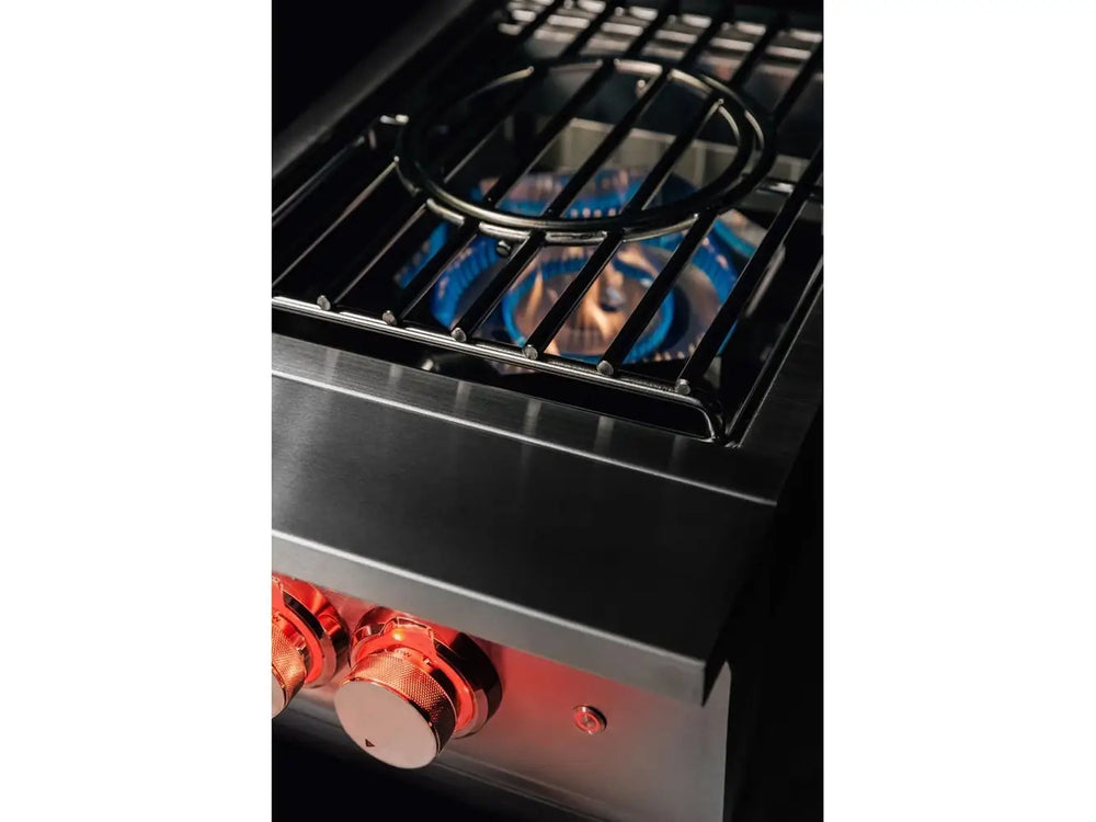 Close-up angle of True Flame wok burner operating with blue flames and heavy-duty round wok ring over flame.