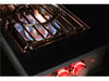 Side view of True Flame wok burner in action with visible blue flames, wok ring, and red-lit knobs glowing in low light.