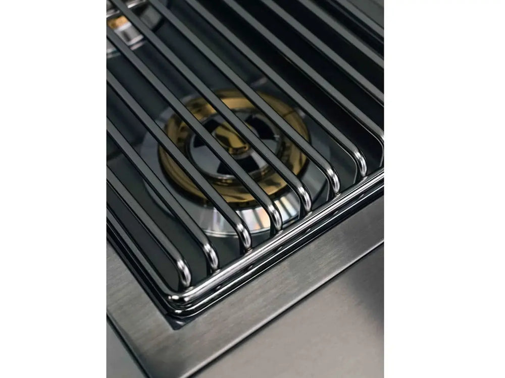Close-up of True Flame burner grate revealing polished brass dual-ring burner underneath.
