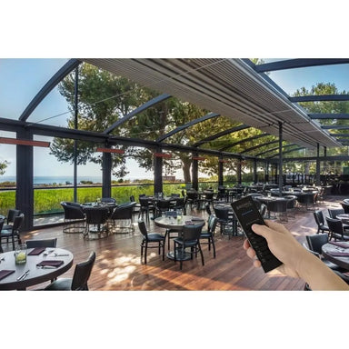 Bromic Wireless Master Remote being used to control outdoor restaurant heaters under a glass roof patio.