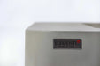 Elementi badge on light gray concrete-look fire table corner.