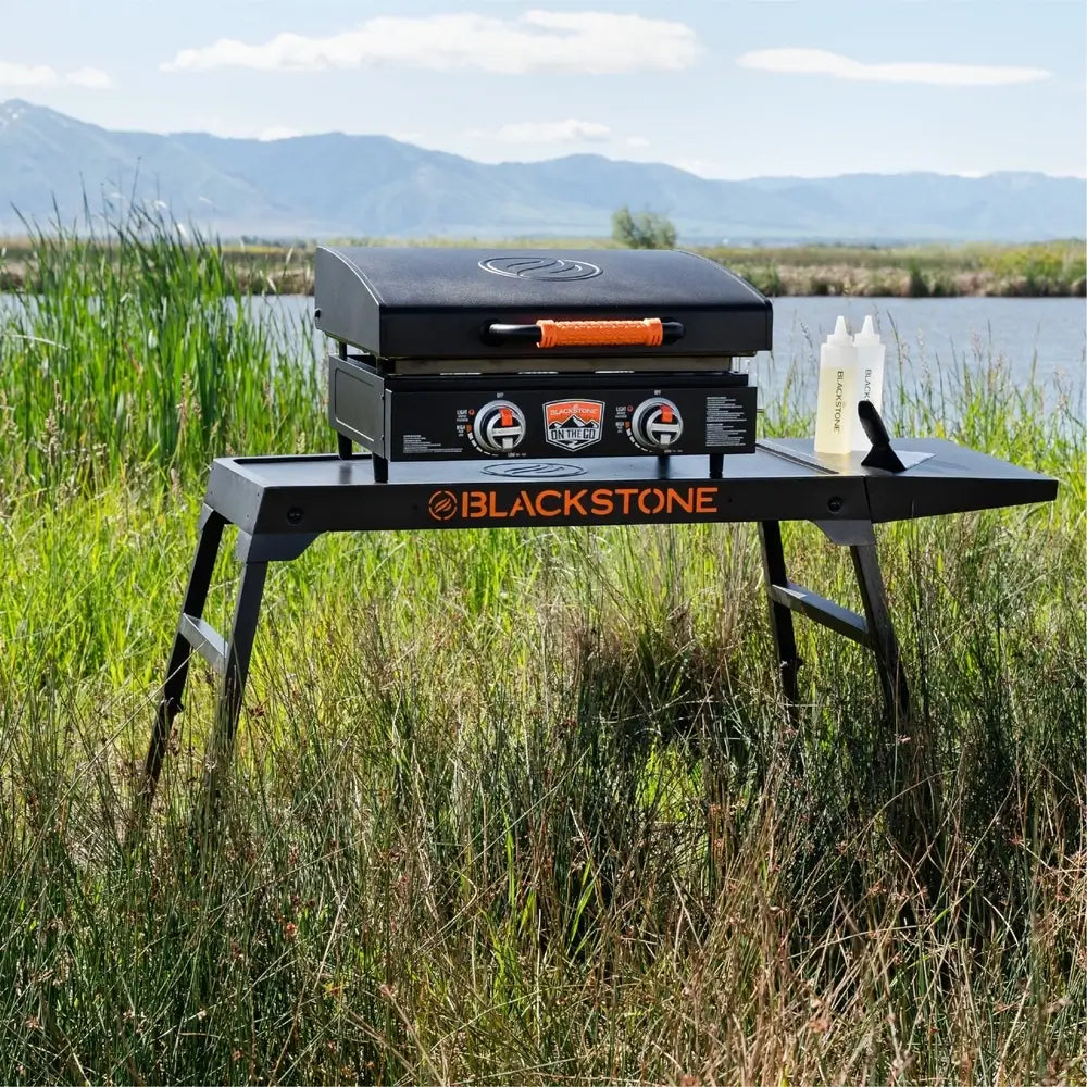 Blackstone griddle in action on Omni Stand with side shelf – ideal outdoor cooking setup with prep space and stability
