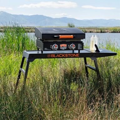Blackstone griddle in action on Omni Stand with side shelf – ideal outdoor cooking setup with prep space and stability