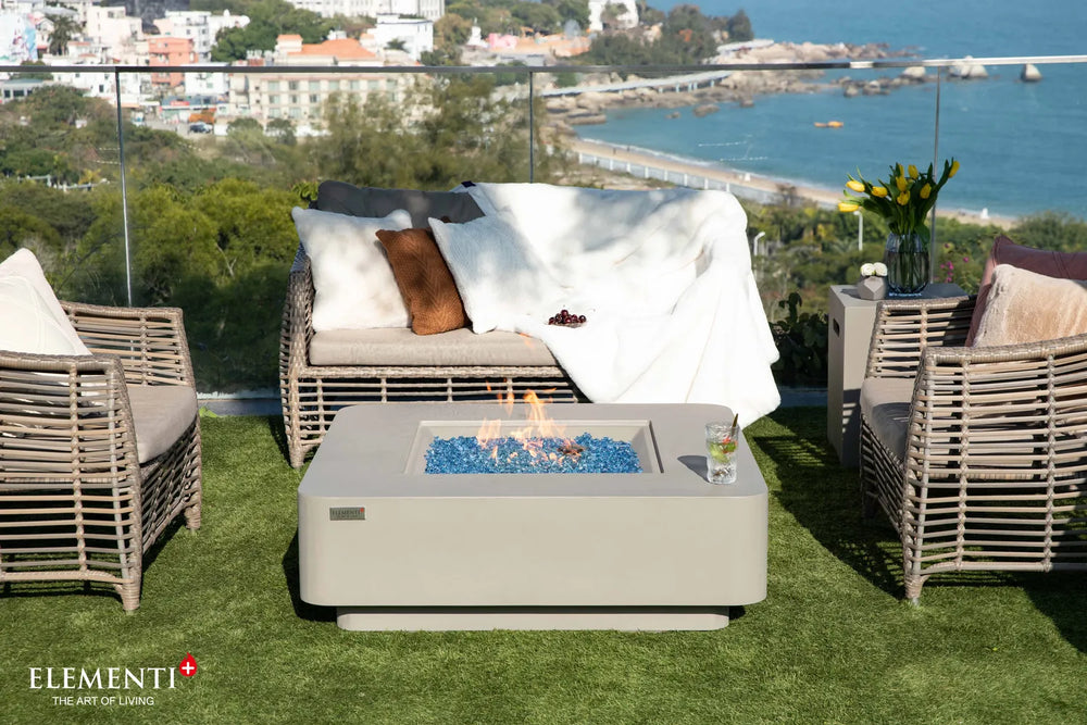 Elementi Plus Lucerne light gray fire table with blue fire glass on rooftop patio seating area.